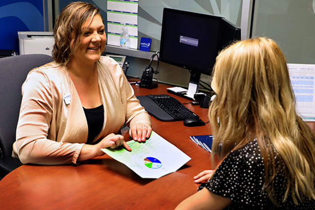 Wildfire Employee happily talking with a member and showing her a brochure